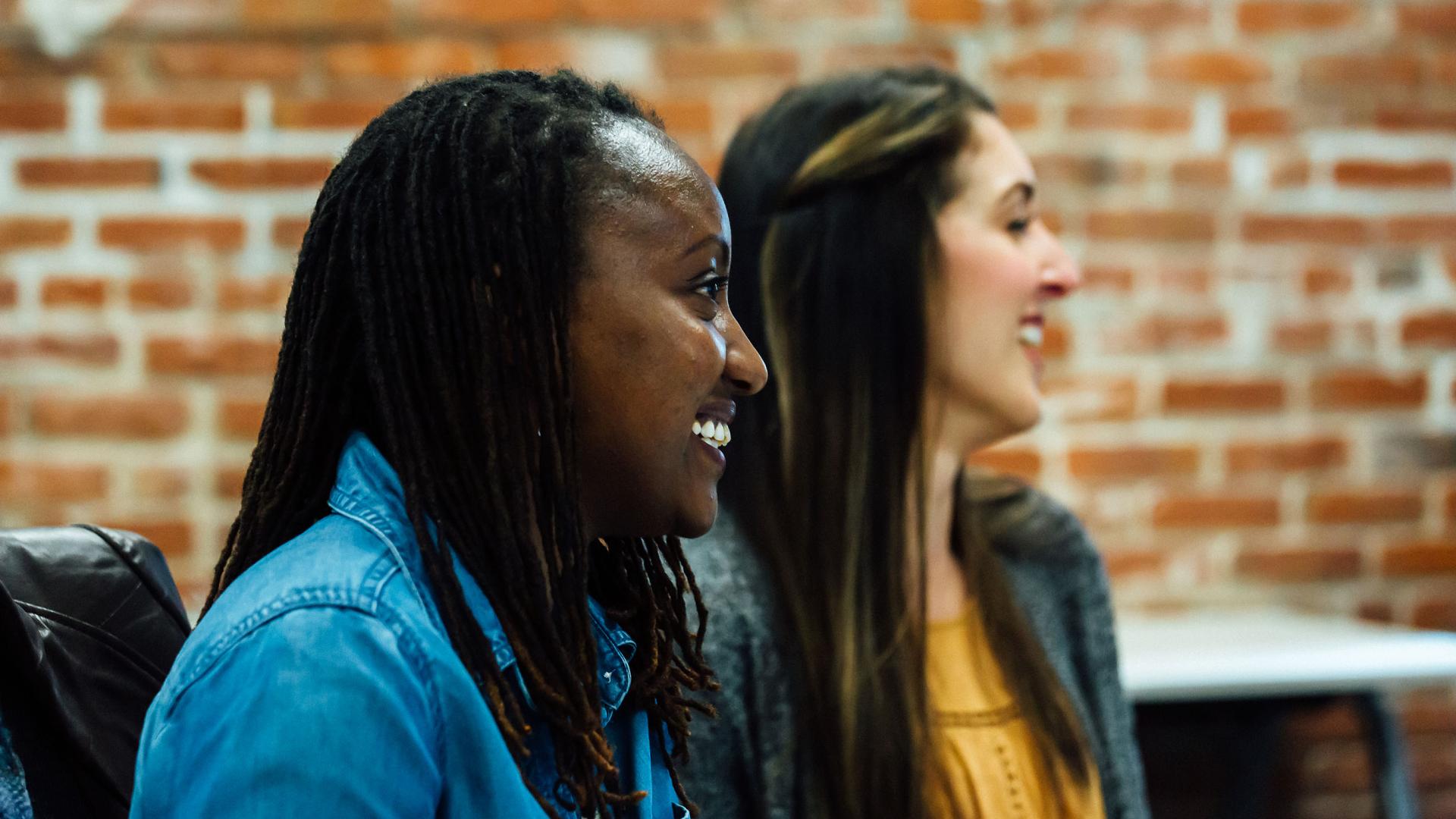 Two people sitting at a table in a classroom