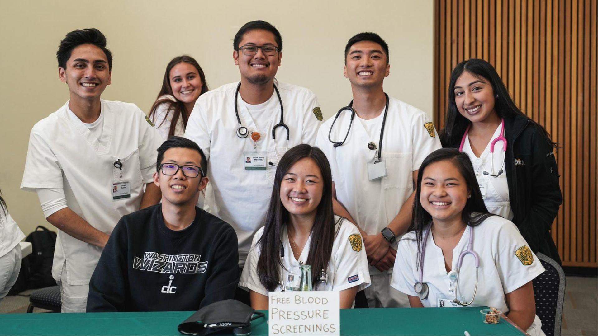 Eight nursing students in group shot promoting blood pressure checks