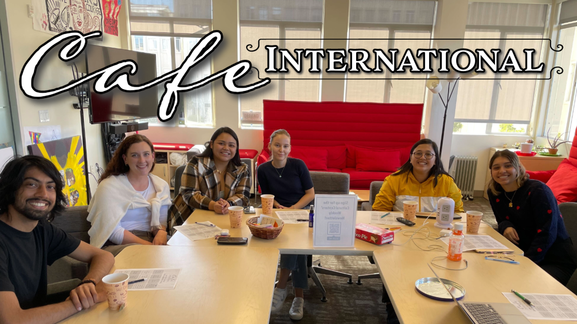 International students smiling and sitting around a table