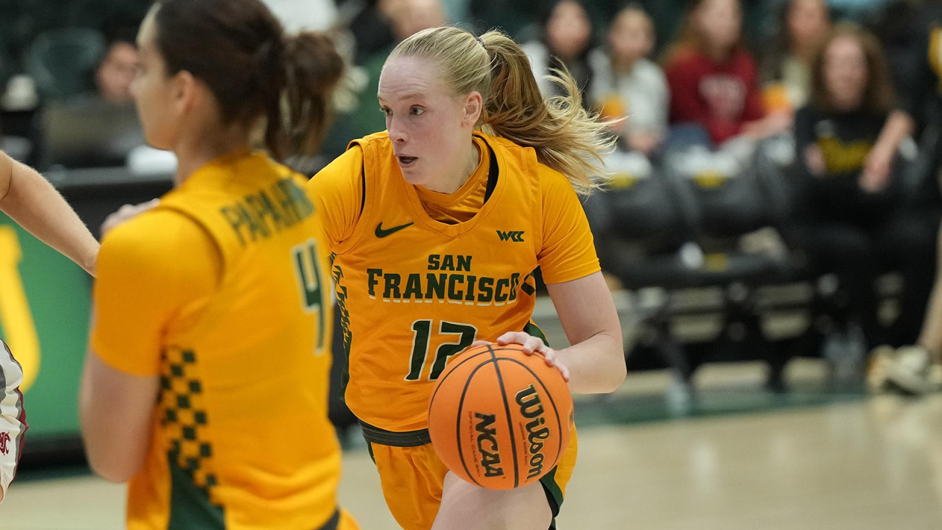 student runs with basketball