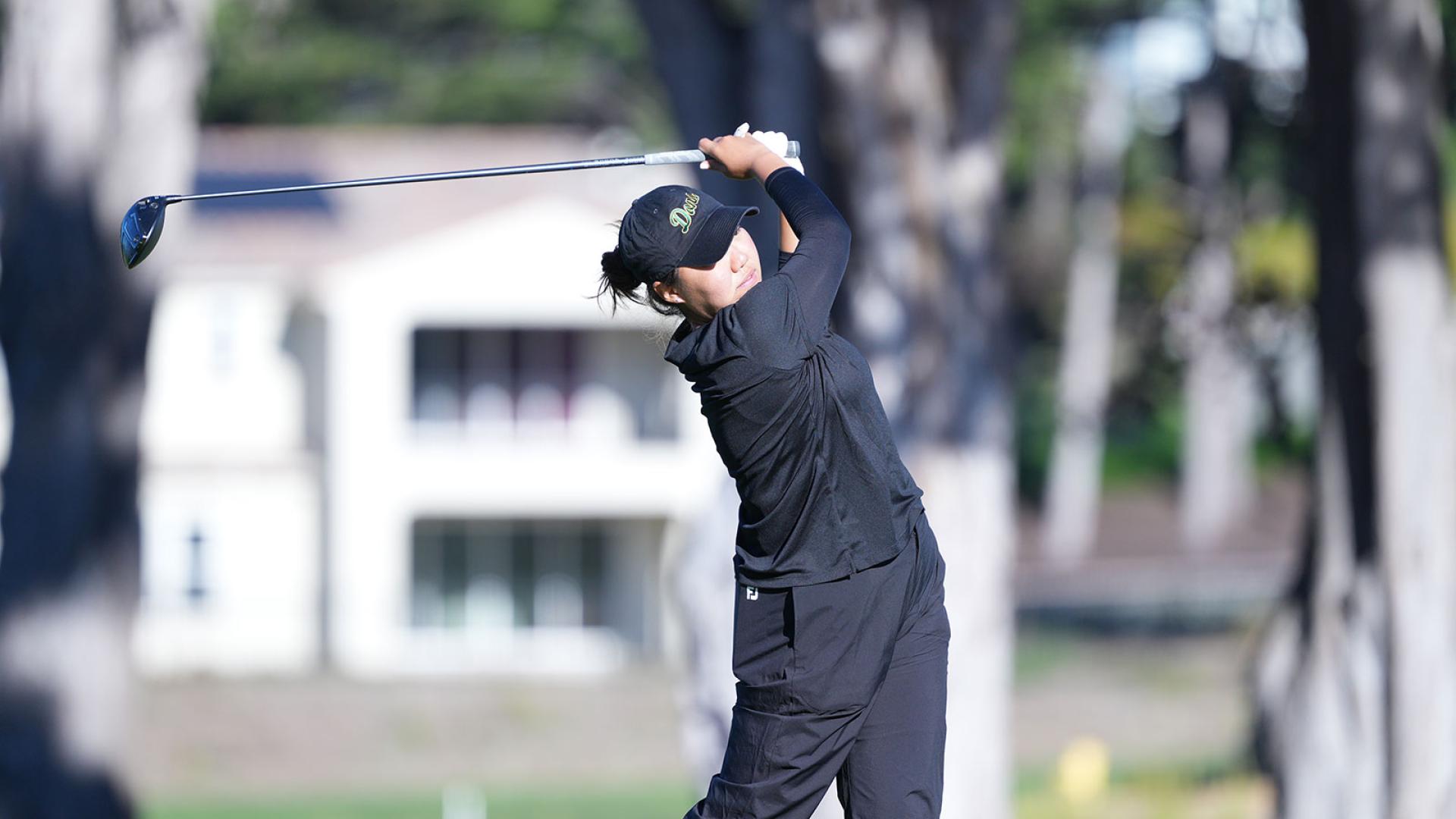 student golfer swings golf club