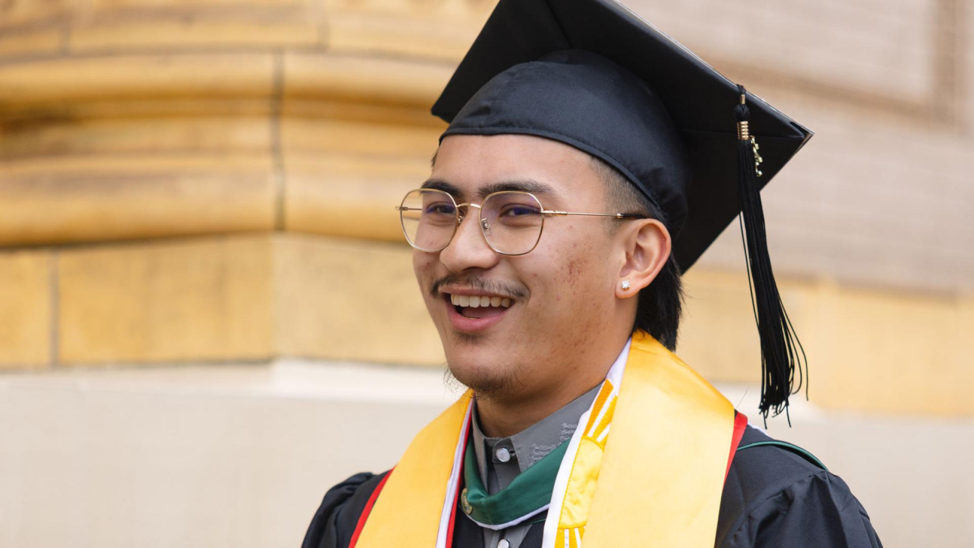 student smiling in cap and gown