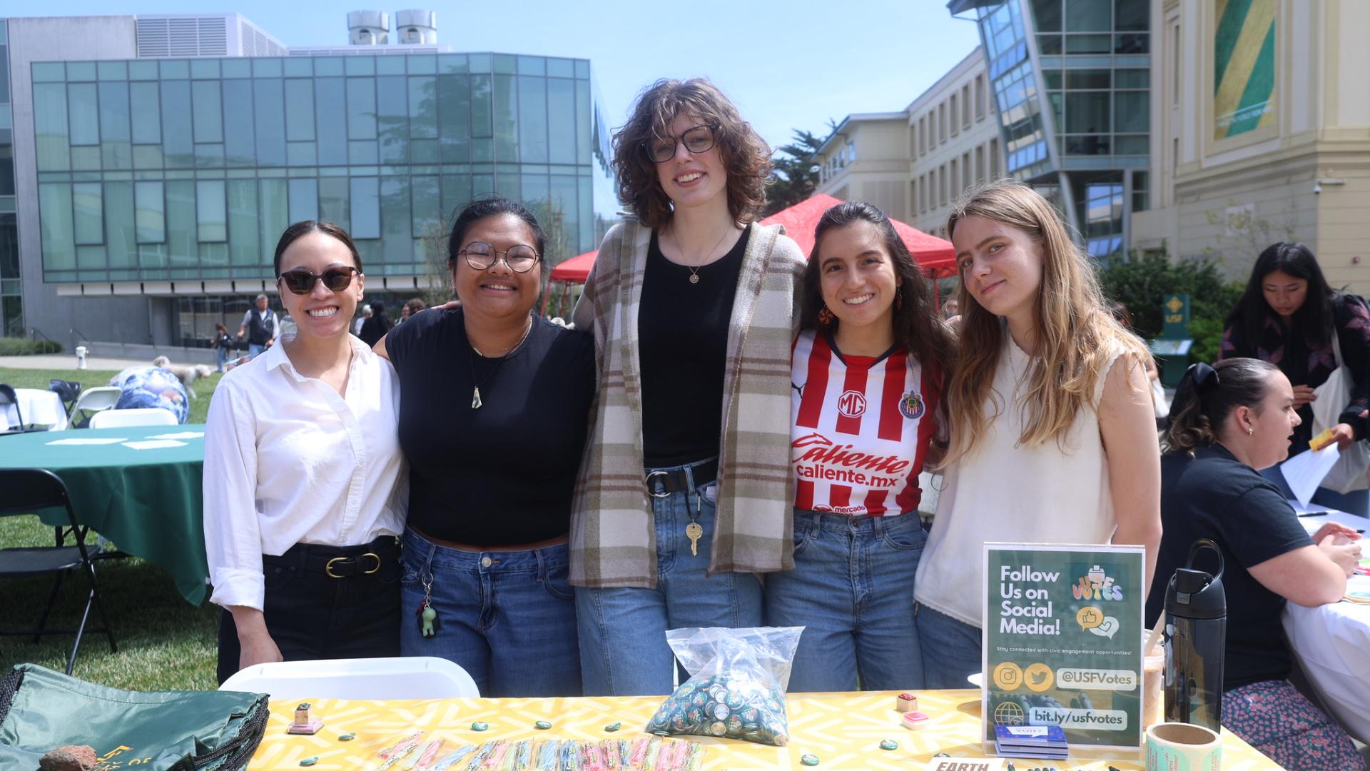 students stand in front of table