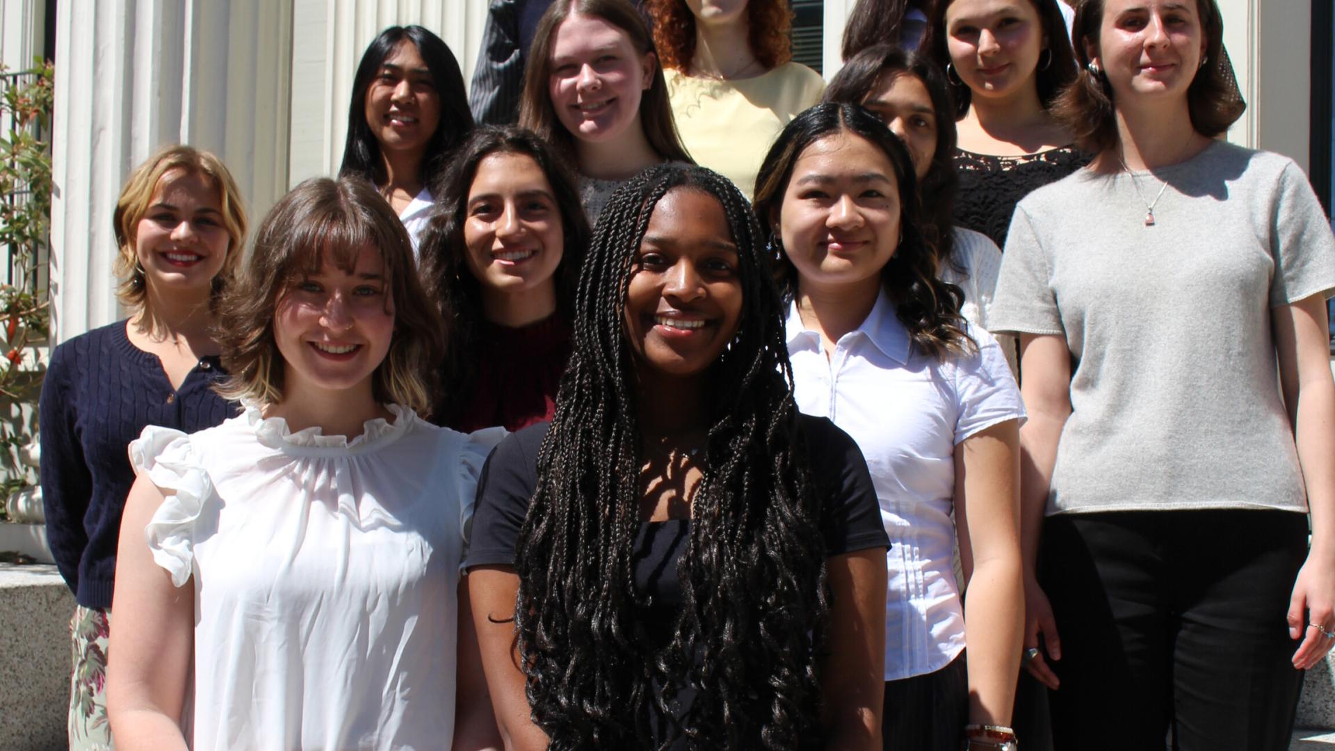 students posing in front of building