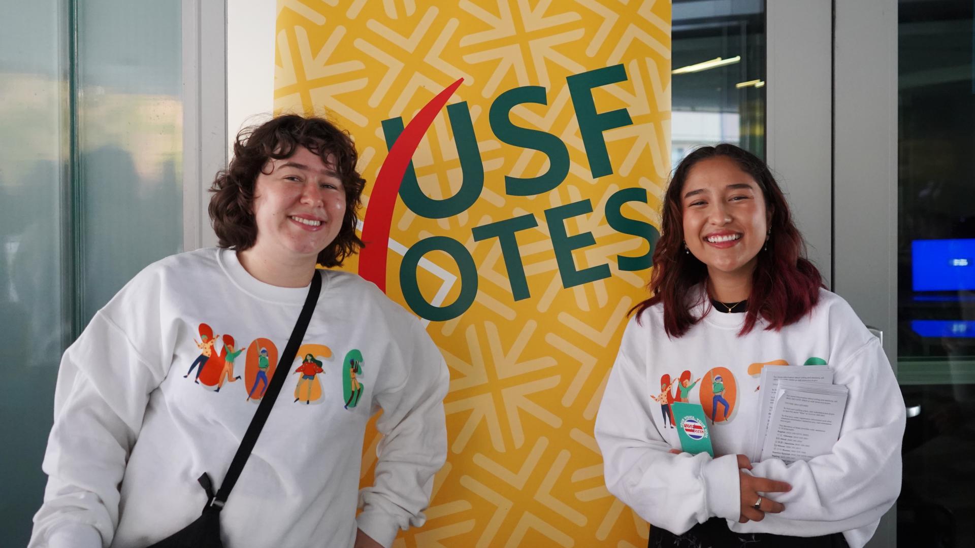 students infront of USF Votes signage