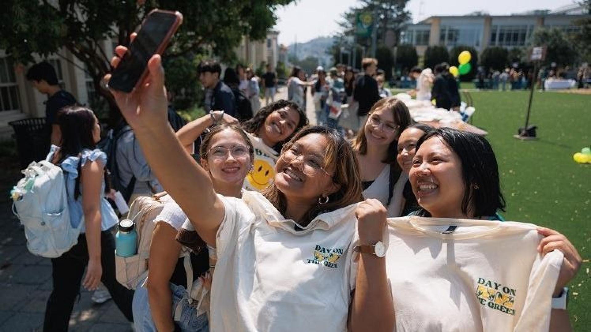 Students taking a selfie on the grass