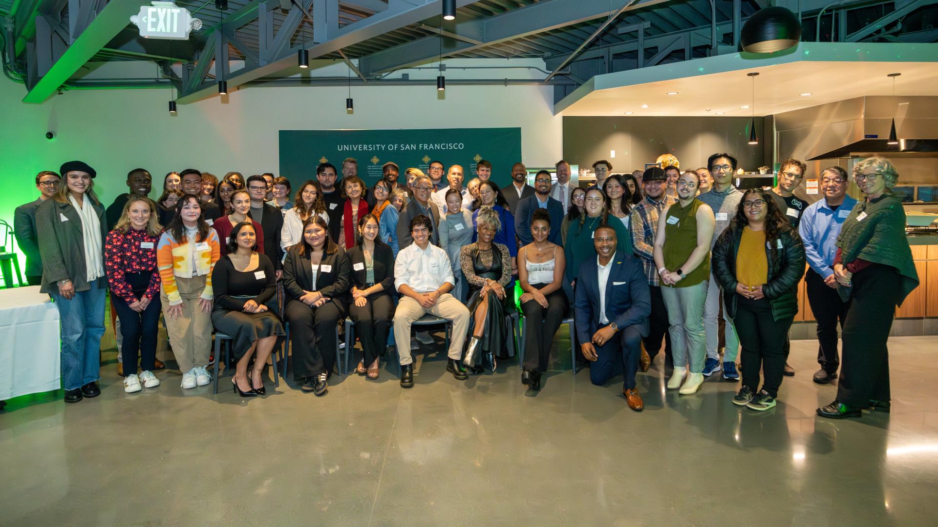 group of people stand in front of a backdrop event