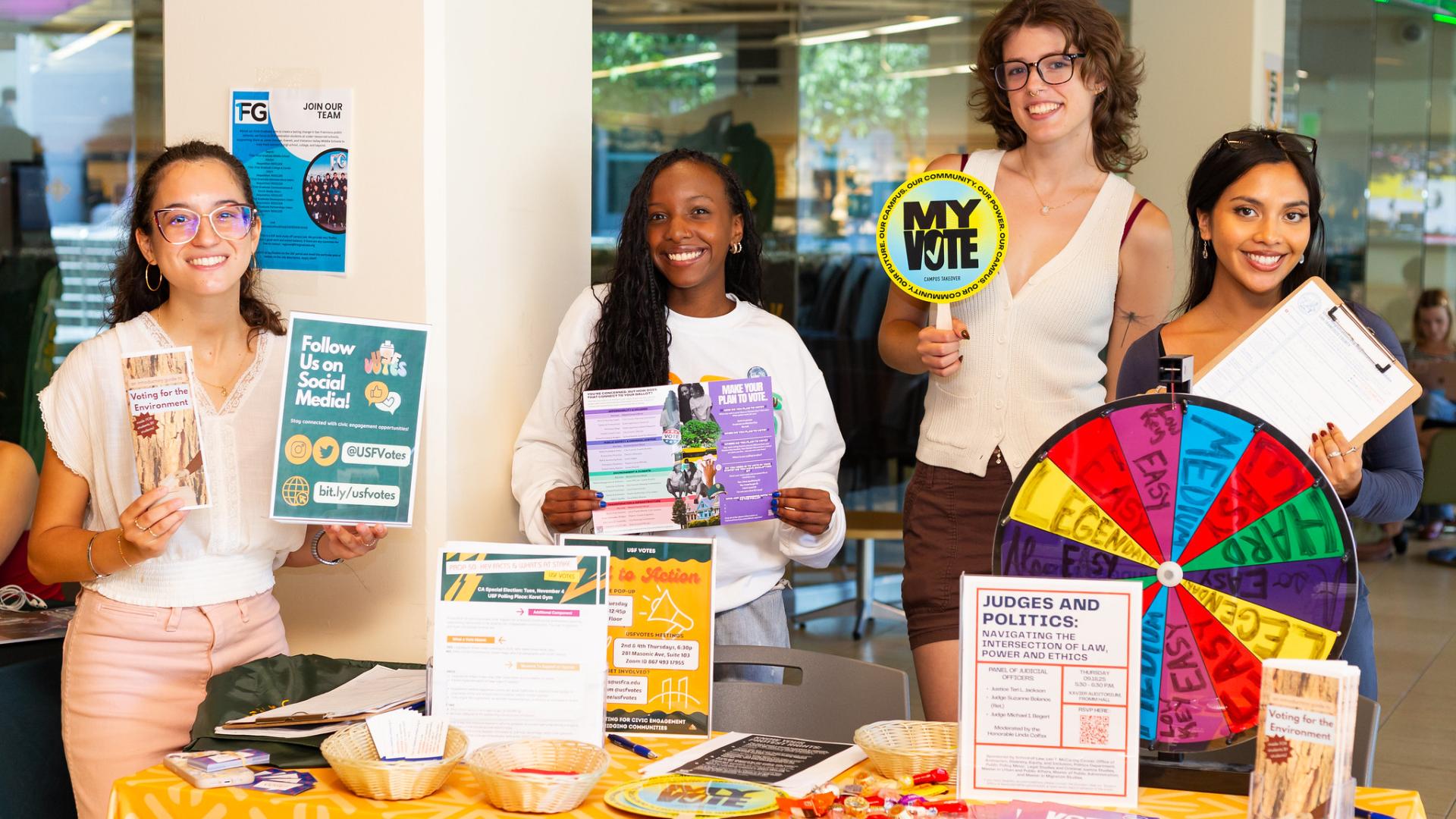 students stand in front of a table with voting materials