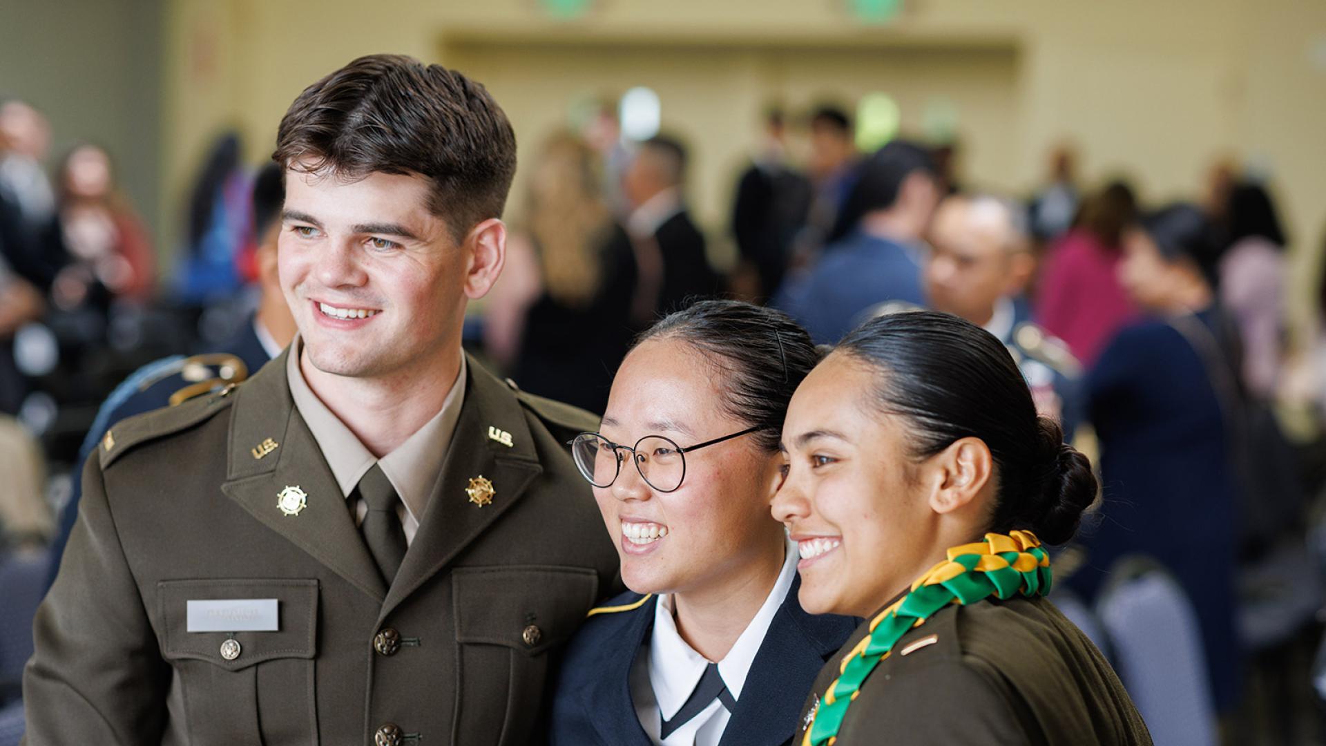 rotc graduating cadet smiles with friends during ceremony