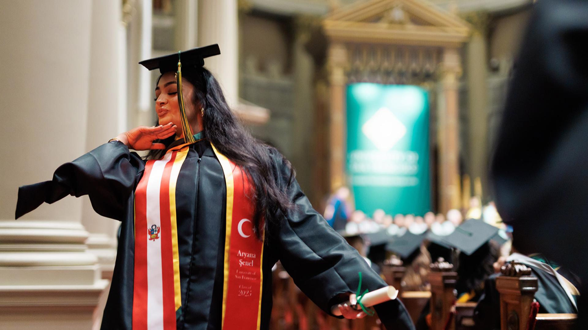 student happily poses inside st.ignatius church during her commencement ceremony