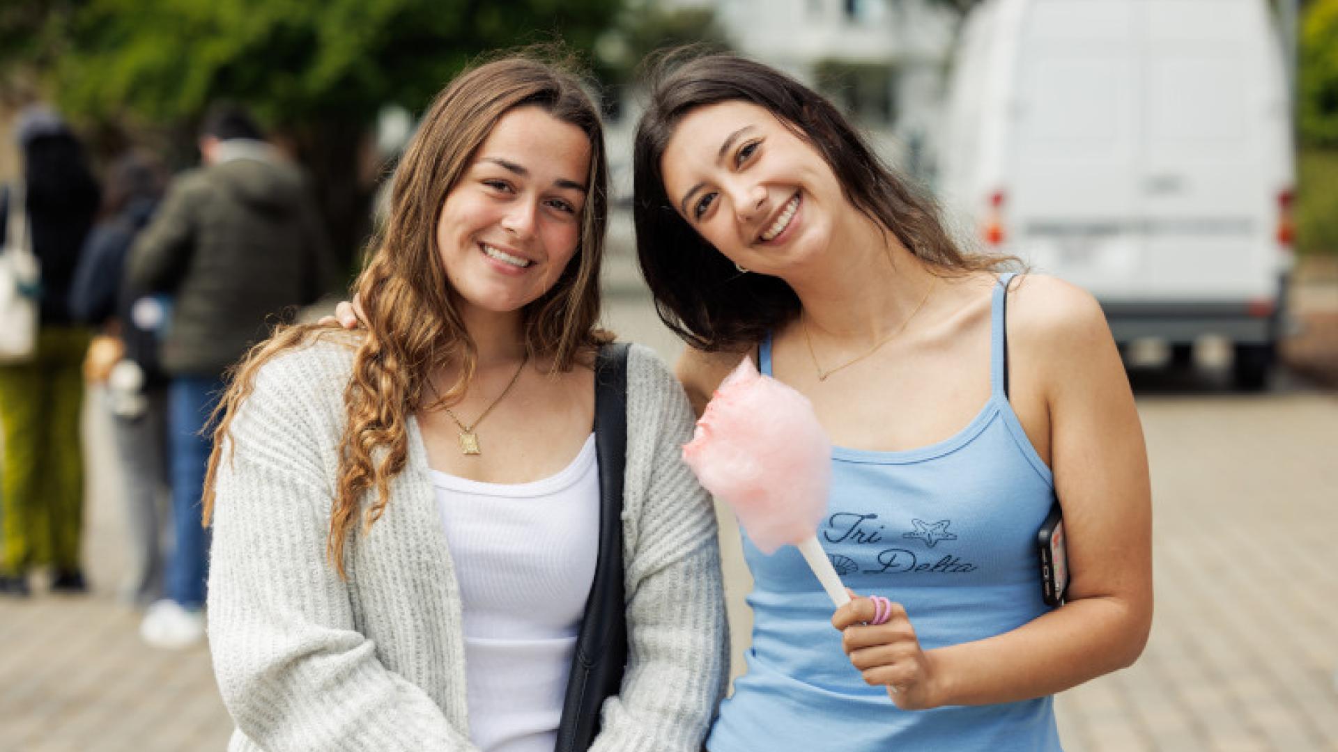 Two students smiling with cotton candy.