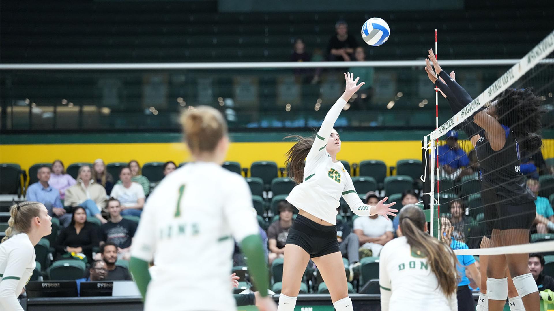 Womens volleyball player reaching for ball