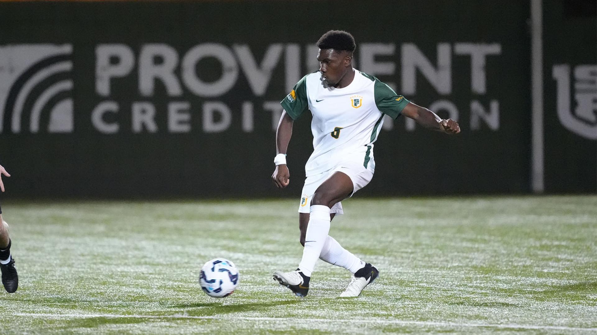 Mens soccer player kicking ball