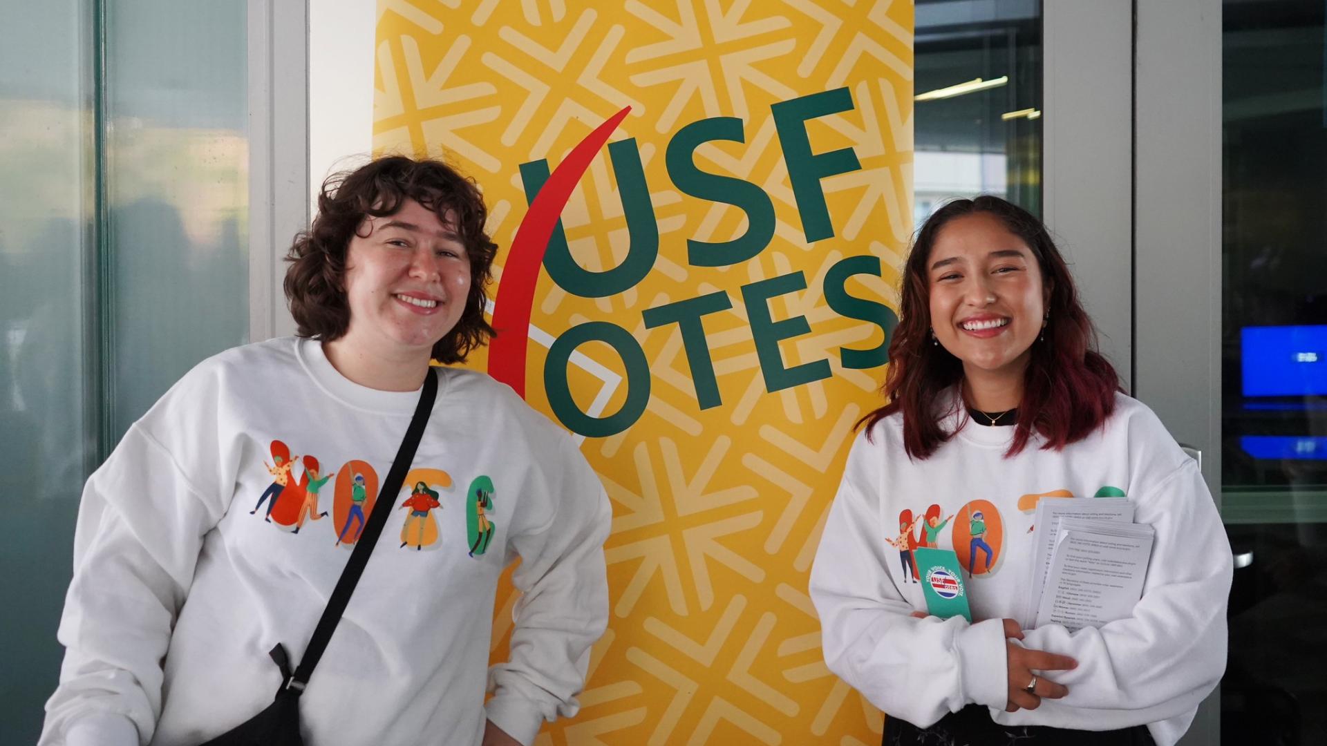students stand in front of sign that says USFVotes