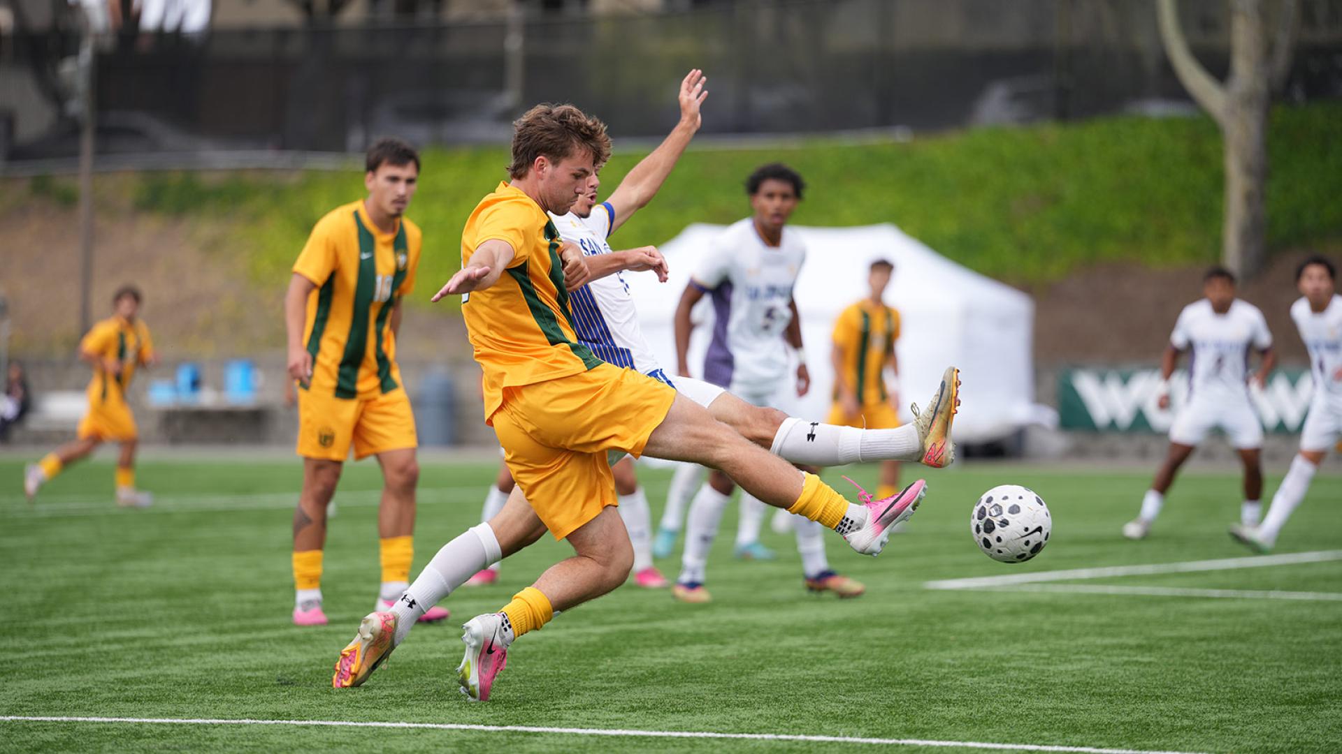 soccer player kicks ball during game